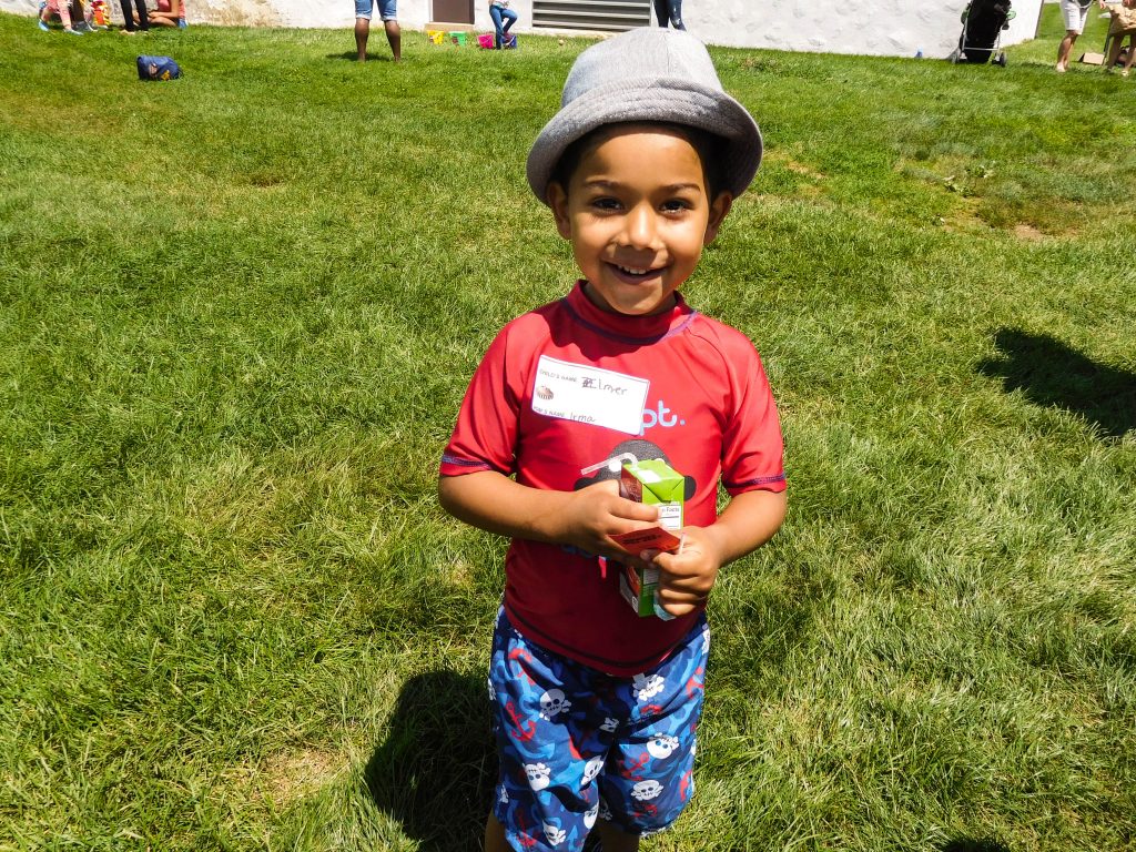 Boy with hat smiling at summer BBQ